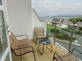 A balcony with chairs and a table at Seaview in Benllech near Red Wharf Bay