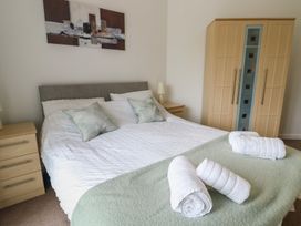 A bedroom with a bed and wardrobe at Seaview in Benllech near Red Wharf Bay