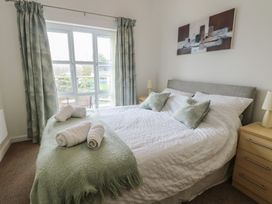 A bedroom with a double bed and window at Seaview in Benllech near Red Wharf Bay