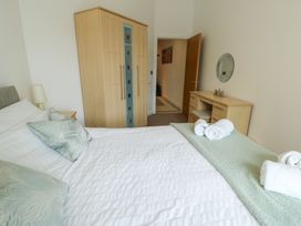 A bedroom with a bed and wardrobe at Seaview in Benllech near Red Wharf Bay