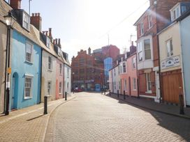 A street with colorful buildings and lampposts at Apartment 1 Brewers Quay in Weymouth