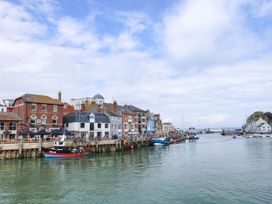 A harbor with boats and buildings at Apartment 1 Brewers Quay in Weymouth