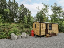 A wooden cabin with outdoor seating and gas canisters at The Hamper in Felingwm near Carmarthen