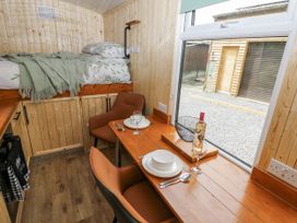 A bedroom with a bed and dining area at The Hamper in Felingwm near Carmarthen