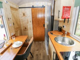 A kitchen with a table and cooking facilities at The Hamper in Felingwm near Carmarthen