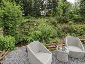 A garden with two chairs and a table at The Hamper in Felingwm near Carmarthen
