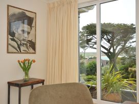 A room with a portrait on the wall and a table with flowers at Bodare 8 Daymer Bay