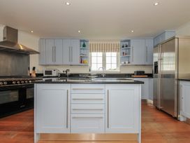 A kitchen with a central island and appliances at Bodare 8 Daymer Bay