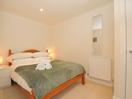 A bedroom with a bed and nightstands at Bodare 8 in Daymer Bay