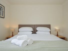 A bedroom with a bed and towels at Bodare 8 in Daymer Bay
