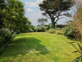 A garden with grass and trees at Bodare 8 Daymer Bay