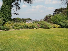 A garden with flower beds and a house at Bodare 8 Daymer Bay