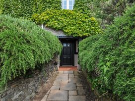 A pathway leading to a door surrounded by hedges at Bodare 8 Daymer Bay