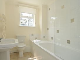 A bathroom with a bath tub and sink at Bodare 8 in Daymer Bay