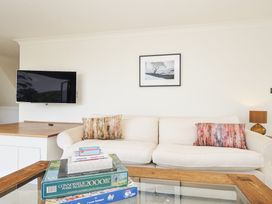 A living room with a sofa and television at Bodare 8 Daymer Bay