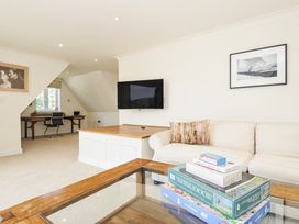 A living room with a sofa and television at Bodare 8 in Daymer Bay