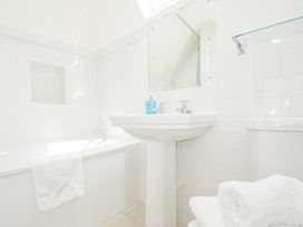 A bathroom with a bath tub and sink at Bodare 8 in Daymer Bay