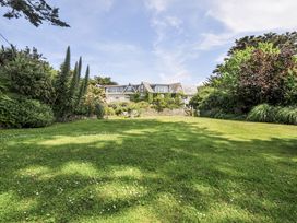 A garden with grass and trees at Bodare 8 in Daymer Bay