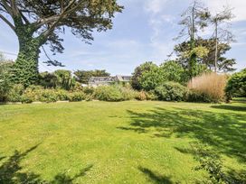 A garden with grass and trees at Bodare 8 Daymer Bay