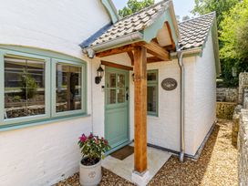 An entrance area with a green door and windows at Stable Cottage in Burley