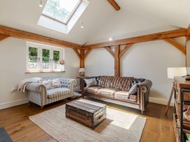 A living room with a sofa and coffee table at Stable Cottage in Burley