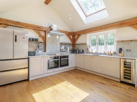 A kitchen with appliances and wooden beams at Stable Cottage in Burley