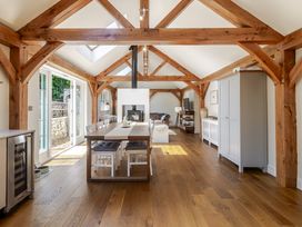 A living room with a dining table and sofa at Stable Cottage in Burley