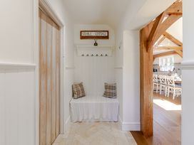 A hallway with a bench and coat hooks at Stable Cottage in Burley