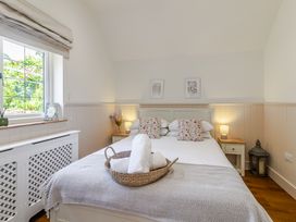 A bedroom with a bed and bedside table at Stable Cottage in Burley