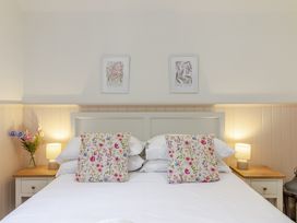 A bedroom with a bed and bedside tables at Stable Cottage in Burley