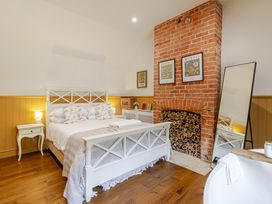 A bedroom with a bed and fireplace at Stable Cottage Burley