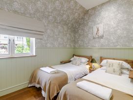 A bedroom with two beds and a window at Stable Cottage in Burley