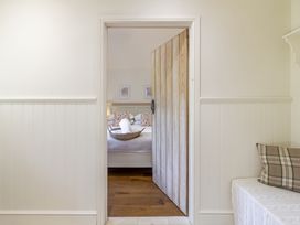 A bedroom with a wooden door and bed at Stable Cottage in Burley