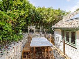 A garden with a wooden table and chairs at Stable Cottage in Burley
