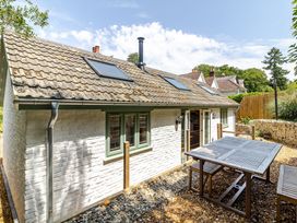 A cottage with a dining table in the garden at Stable Cottage Burley