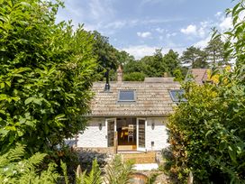 A cottage with a patio and garden at Stable Cottage in Burley