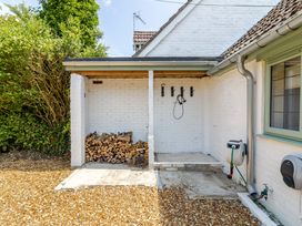 An outdoor area with logs, a wall with hooks and shower head at Stable Cottage in Burley
