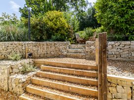 Steps leading to a seating area in a garden at Stable Cottage in Burley