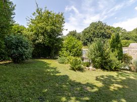 A garden with various trees and shrubs at Stable Cottage in Burley