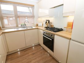 A kitchen with wooden countertops gas stove oven sink and window blinds at Finnbars Lodge in Richmond