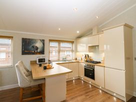 A kitchen with wooden countertops two chairs a microwave and an elephant painting at Finnbars Lodge in Richmond