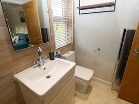 A bathroom with a sink cabinet toilet mirror and window blinds at Finnbars Lodge Richmond