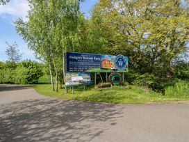 An entrance sign for Badgers Retreat Park holiday park surrounded by trees and greenery at Finnbars Lodge in Richmond