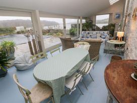 A conservatory with a table and chairs at Curlew House in Cosheston