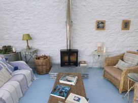 A snug with a wood stove and seating at Curlew House in Cosheston