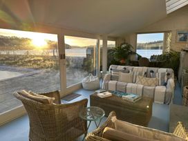 A conservatory with a sofa and coffee table at Curlew House in Cosheston
