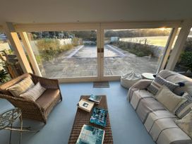 A conservatory with seating and a view of the patio at Curlew House in Cosheston