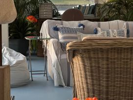 A snug with a sofa and cushions at Curlew House in Cosheston