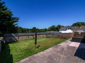 A garden with grass and a bench at West View in Northlew near Hatherleigh