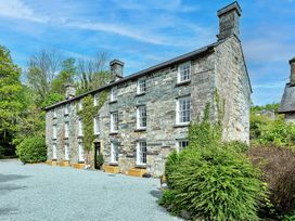 A stone building with windows and landscaping at Snowdonia Manor in Dolgellau